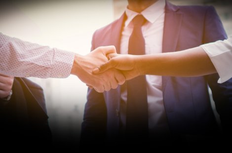 Image of people in business attire shaking hands. 