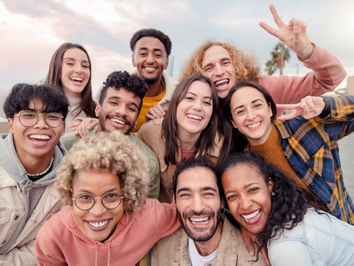 A diverse group of individuals smiling and posing together for a cheerful photo.