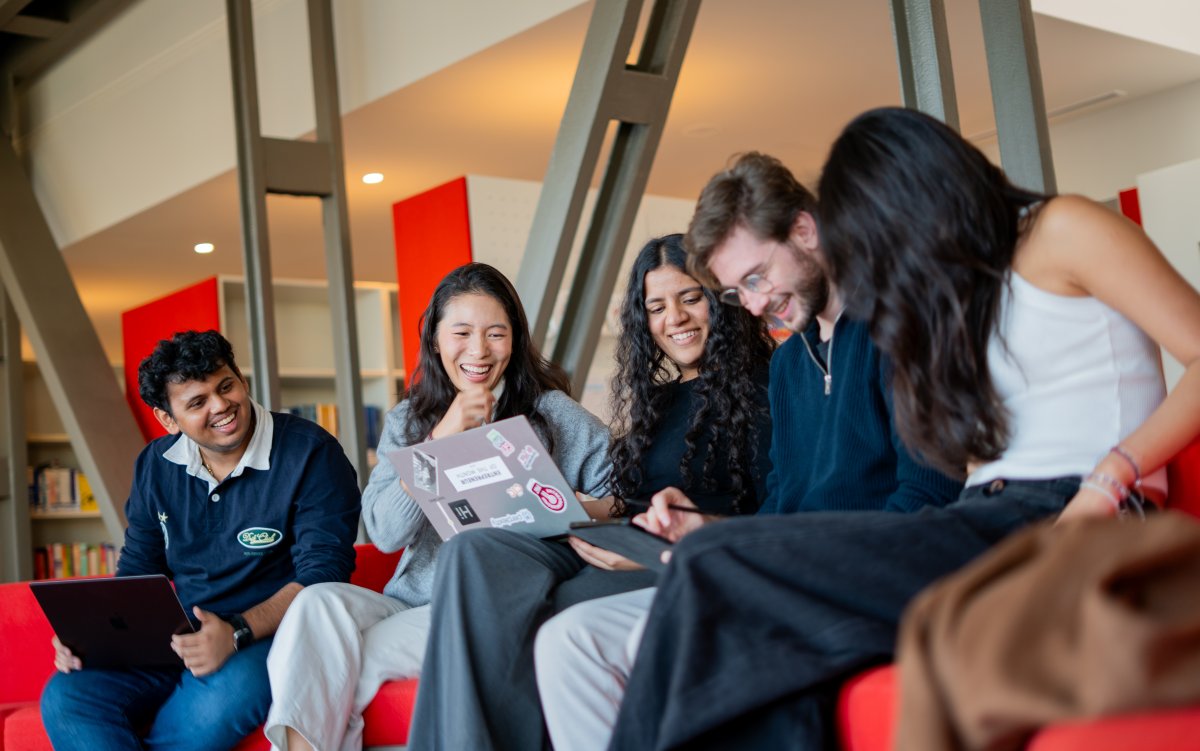 ESMT Berlin master's students laughing together in the campus library