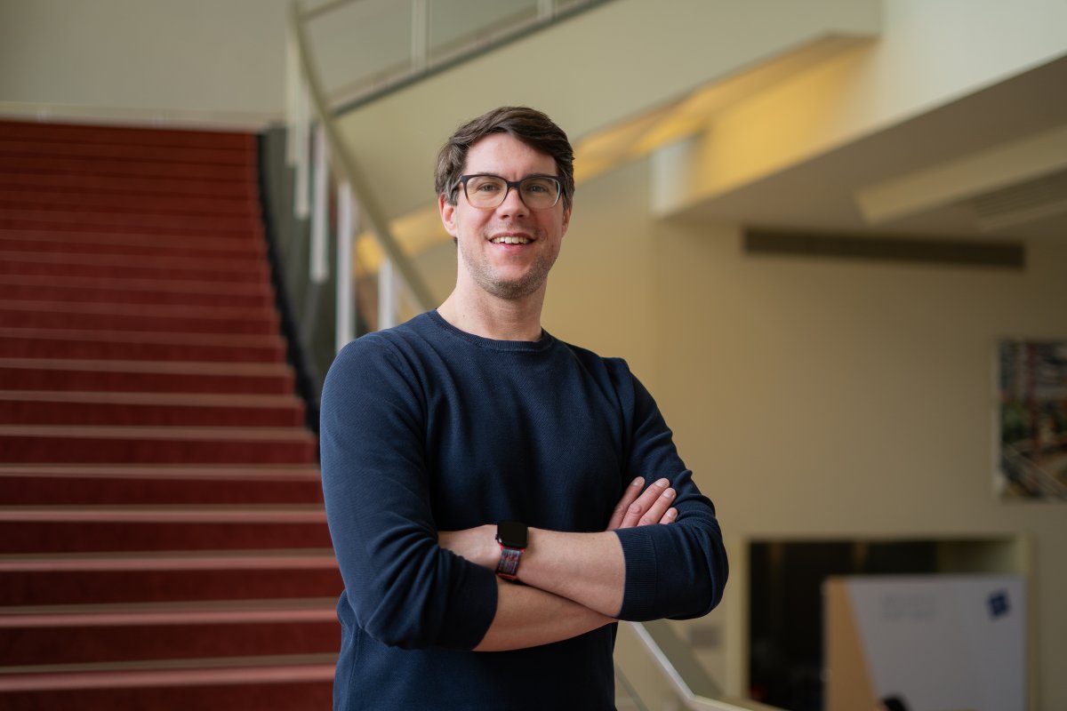 The ESMT Part-time MBA student Jan Zimmermann standing by the staircase on campus