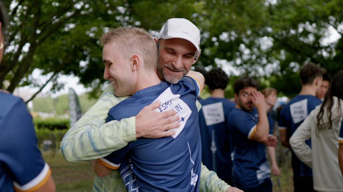 ESMT Berlin professor Eric Quinane hugging a student after a successful relay race
