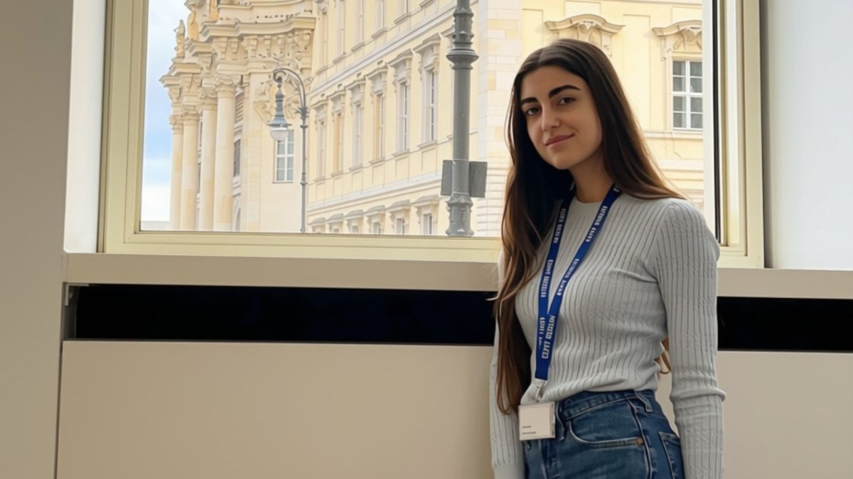 ESMT Part-time MBA student Sophie Khalil in a lecture room on the ESMT campus, in front of a view of the Humboldt Forum