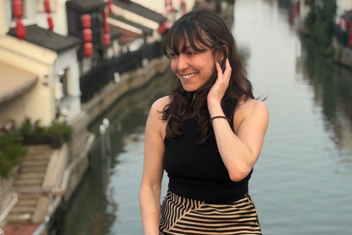 ESMT Berlin Part-time MBA student Flor Massei sitting on a canal bridge in Shanghai, China, during an international program component