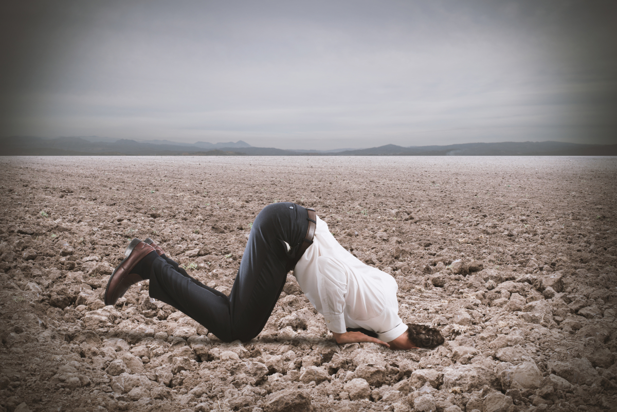 Afraid businessman hides his head