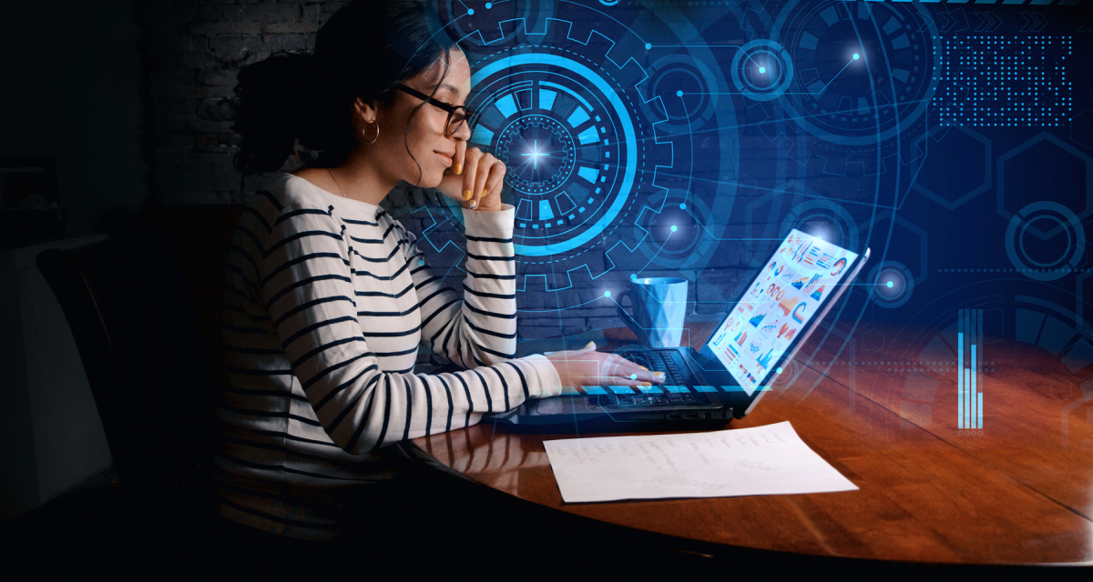 woman sitting at desk working on laptop with digital graphics surrounding her