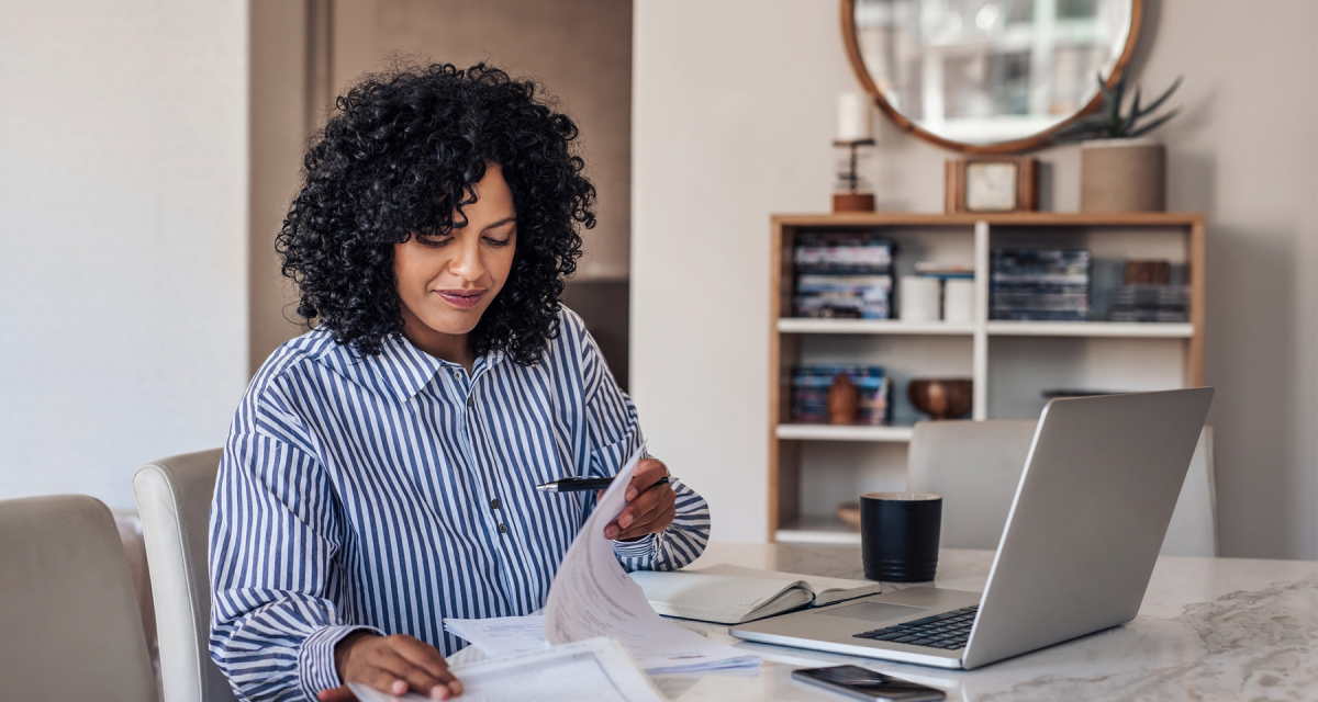 Female sitting at table working from home on laptop