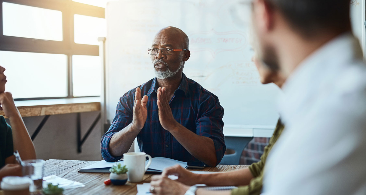 African American male leading a business meeting