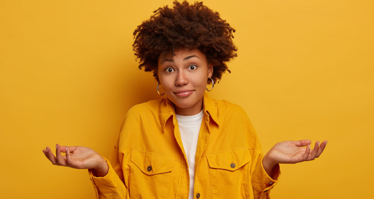 Puzzled African American woman shrugs shoulders and expresses uncertainty