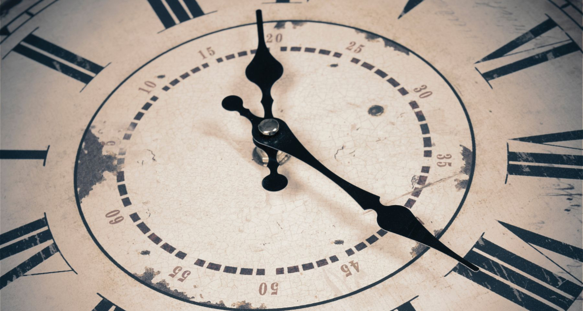 Old clock in Roman numerals, reading 20 minutes past 12