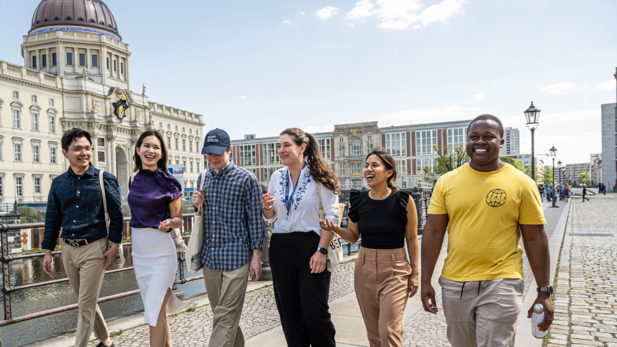 Divers group of ESMT students walking in Berlin with ESMT building in the background