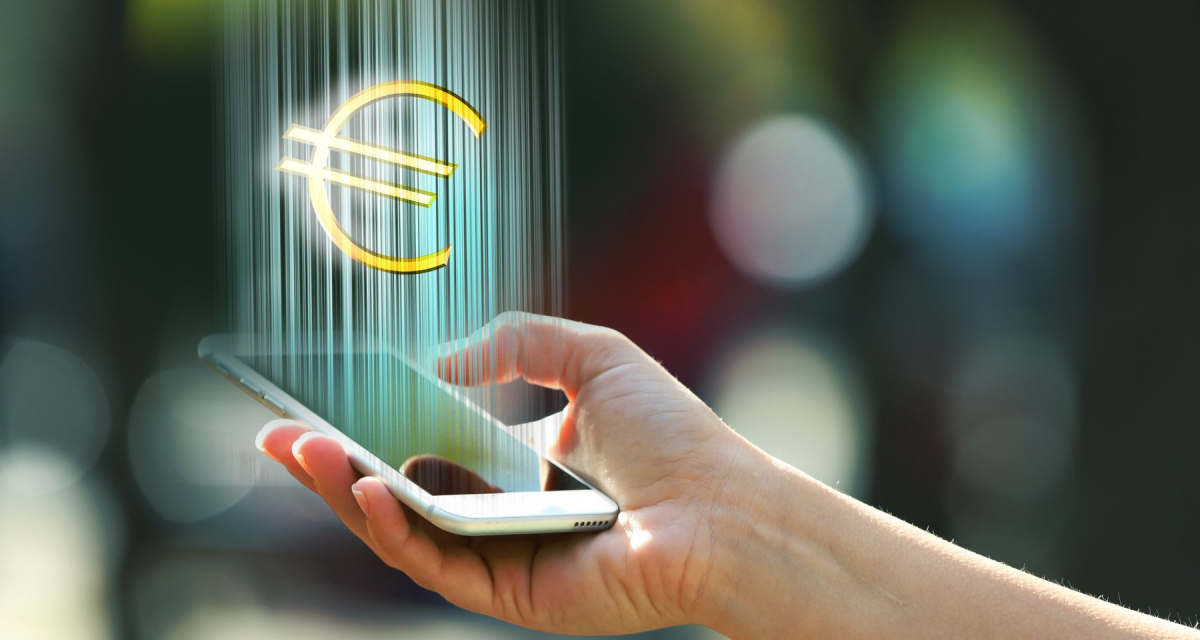 Hand holding a mobile phone with euro sign outdoors, on blurred background