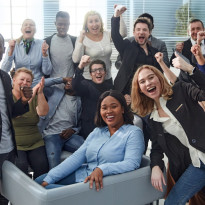 diverse office team smiles and cheers for the camera