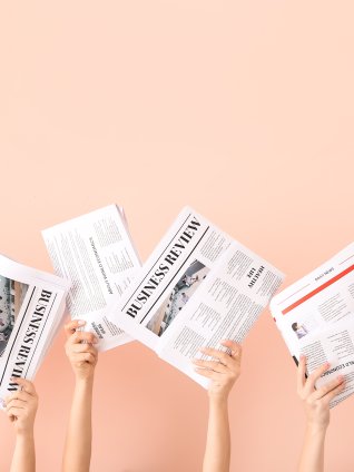 Female hands with newspapers on color background 