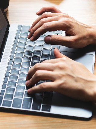 a man typing on the laptop