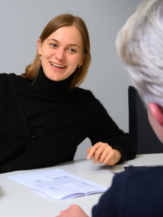 female professional speaking to an older male professional