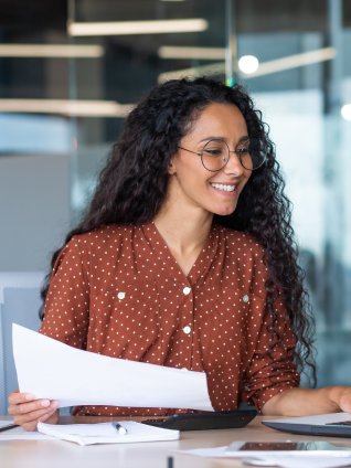 Female professional smiling and doing work on the laptop