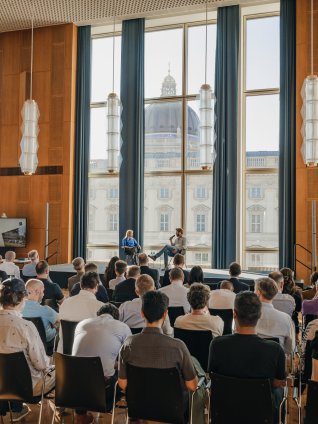 Photo of a large alumni group in the auditorium at the ESMT Berlin campus 
