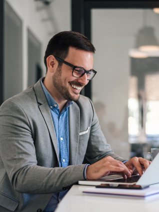 Man working on the computer and smiling. 