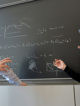 2 professors having a discussion at blackboard
