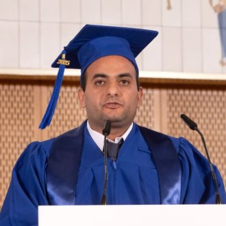 ESMT Berlin Global Online MBA alum Michael Seruig speaking on stage at graduation