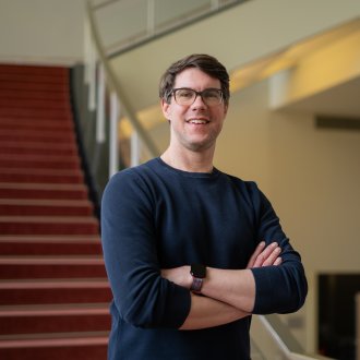 The ESMT Part-time MBA student Jan Zimmermann standing by the staircase on campus