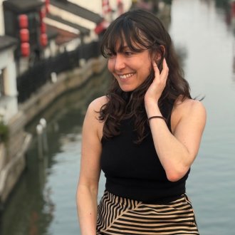 ESMT Berlin Part-time MBA student Flor Massei sitting on a canal bridge in Shanghai, China, during an international program component