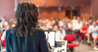 Woman speaking to audience at a conference