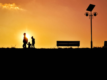 A family silhouette against a sunset backdrop