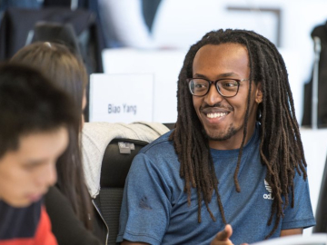 student smiling at other student 