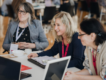 three females smiling and listening