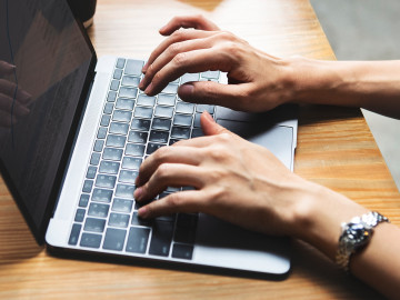 a man typing on the laptop