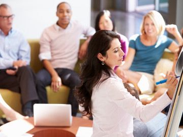 Businesswoman Making Presentation To Office Colleagues