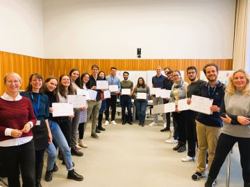 groups of people smiling into camera and holding their certificates up
