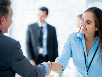 A female professional shaking hands with a male professional