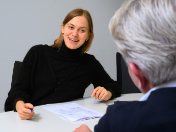 female professional speaking to an older male professional