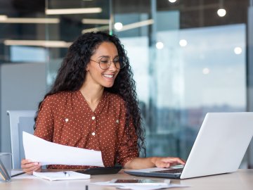 Female professional smiling and doing work on the laptop