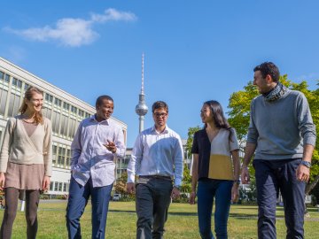 ESMT Berlin students in the campus garden, with the Berlin TV Tower in the background