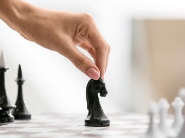 female hand is moving a chess piece