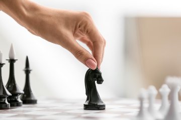 female hand is moving a chess piece