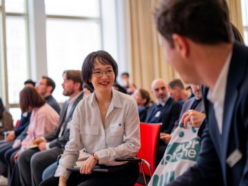 Full-time MBA student Lindy Lin at an ESMT Berlin career fair, smiling with another course mate
