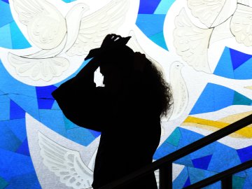 Graduating woman in front of the stained glass window at ESMT Berlin