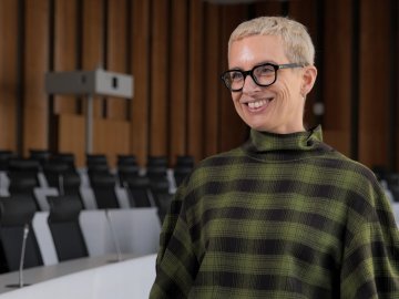 Rebecca Loades, Program Director for the Full-time MBA at ESMT Berlin, giving an interview about the program. She is smiling and wearing a green plaid top.