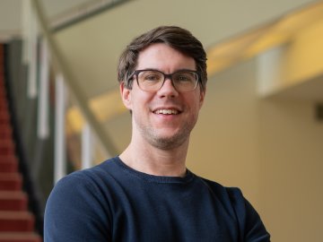 The ESMT Part-time MBA student Jan Zimmermann standing by the staircase on campus