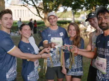 ESMT Berlin students and faculty show their medals after running the Berliner Wasserbetriebe 5 x 5 relay race together