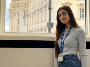 ESMT Part-time MBA student Sophie Khalil in a lecture room on the ESMT campus, in front of a view of the Humboldt Forum