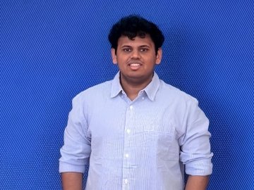 ESMT Berlin Master in Innovation and Entrepreneurship student Vaibhav Jain standing in front of a bright blue wall
