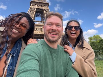 ESMT Berlin Full-time MBA students Roshni, Scott, and Tammy at the Eiffel Tower on a class trip to Paris