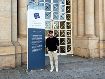 ESMT Full-time MBA student Rishabh Babbar standing outside the main campus building 