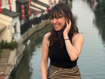 ESMT Berlin Part-time MBA student Flor Massei sitting on a canal bridge in Shanghai, China, during an international program component