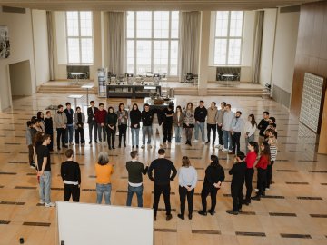 ESMT students taking part in a business-development bootcamp. They are standing in a circle in one of the campus event vestibules